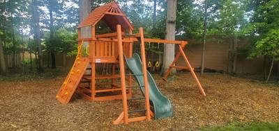 wooden Woodplay playset with monkey bars and slide with climbing